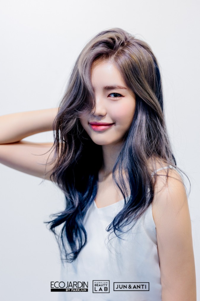 굵은 웨이브로 분위기 있는 스타일을 연출하고 앞머리 라인 포인트로 얼굴의 광대 라인 부분을 커버한 헤어스타일